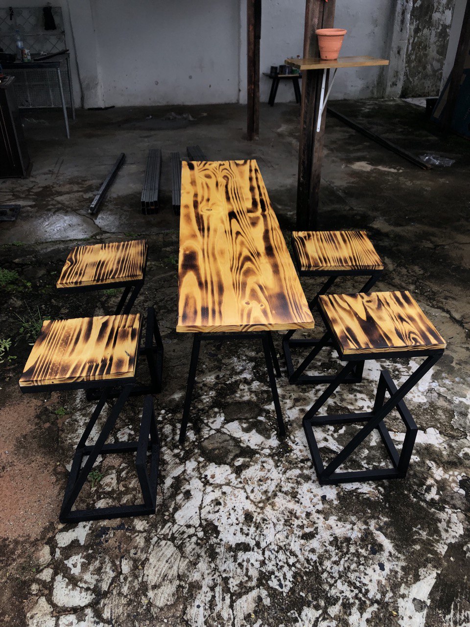 Conjunto Bistrô Safari Flame – Mesa e 4 Banquetas em Madeira Queimada e Aço